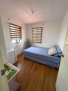 um quarto com uma cama e duas janelas em Fully furnished spacious house in Nuvali em Calamba