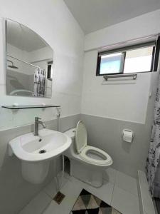 uma casa de banho branca com um WC e um lavatório em Fully furnished spacious house in Nuvali em Calamba