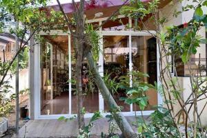 uma casa com um alpendre com janelas e árvores em Fully furnished spacious house in Nuvali em Calamba