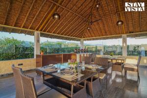 uma sala de jantar com uma mesa e algumas cadeiras em Hriday Bhoomi with Pool at Jim Corbett by StayVista em Jhirna