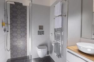 a white bathroom with a toilet and a sink at Anyday Apartments in Prague