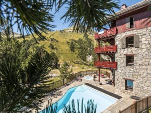 a house with a swimming pool next to a building at Résidence Les Arcs Le Village - maeva Home - Appartement Pièces Pers. Prest 90 in Bourg-Saint-Maurice