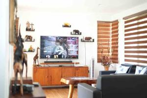 uma sala de estar com televisão num centro de entretenimento em madeira em Fully furnished spacious house in Nuvali em Calamba