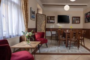 een woonkamer met een tafel en stoelen en een televisie bij Anyday Apartments in Praag