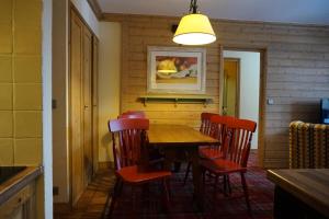 ein Esszimmer mit einem Holztisch und Stühlen in der Unterkunft Résidence Les Arcs Le Village - maeva Home - Appartement pièces Confort 91 in Bourg-Saint-Maurice
