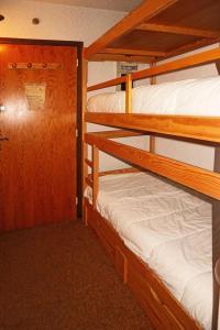 a bunk bed room with two bunk beds and a door at Résidence LA SEILLE - Studio pour 4 Personnes 974 in Les Orres