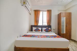 a bedroom with a large bed in front of a window at FabHotel Buddha Sunrise in Patna