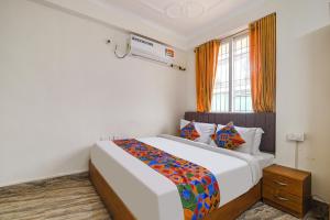 a bedroom with a bed and a window at FabHotel Buddha Sunrise in Patna