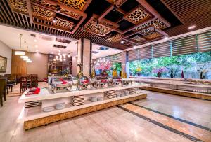 un restaurante con mesas y sillas en una habitación en Muong Thanh Grand Xa La Hotel, en Hanói
