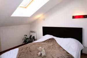 a teddy bear sitting on a bed in a bedroom at RESIDENCE LA COMBE D OR - 2 Pièces pour 4 Personnes 324 in Les Orres