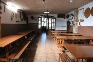 un ristorante vuoto con tavoli e panche in legno di Casa rural para grupos a Ayora