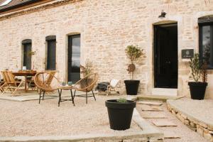 un patio con mesa y sillas y un edificio de ladrillo en gîte les Blés Dorés, en Corgengoux