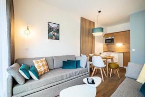 salon z kanapą i stołem w obiekcie Résidence Les Rives de L'Aure - maeva Home - Appartement 2 pièces 5 personnes - Sélection MAE-6737 w mieście Saint-Lary-Soulan