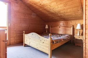 a bedroom with a bed in a wooden cabin at Chalet Forsythia - Chalets pour 10 Personnes 91 in Peisey-Nancroix