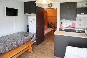 a room with a kitchen and a bed in a room at Résidence Les 7 Berge - Studio pour 5 Personnes 614 in Les Orres