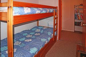 a bunk bed with a blue comforter on it at Résidence Les 7 Berge - Studio pour 5 Personnes 614 in Les Orres