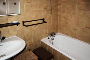 a bathroom with a bath tub and a sink at Résidence Les 7 Berge - Studio pour 5 Personnes 614 in Les Orres