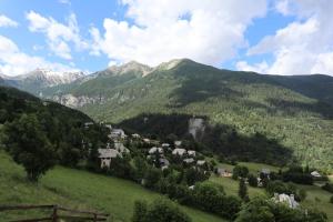 a village in a valley with mountains in the background at Résidence Les 7 Berge - Studio pour 5 Personnes 614 in Les Orres