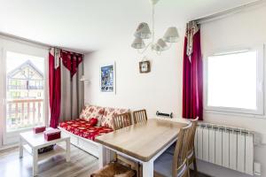 uma sala de estar com uma mesa e um sofá em Résidence Le Thabor - maeva Home - Appartement 2 Pièces 5 Personnes - Confo 73 em Le Désert