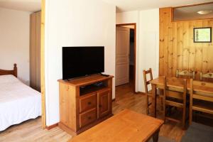 - une chambre avec un lit et une télévision sur une armoire en bois dans l'établissement Résidence Les Colchiques - 2 Pièces pour 6 Personnes 604, aux Orres