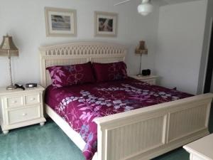 een slaapkamer met een bed met paarse lakens en 2 nachtkastjes bij Five-Bedroom Pool Home Davenport in Davenport