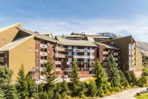 un immeuble d'appartements avec une montagne en arrière-plan dans l'établissement Résidence Les Horizons d'Huez - maeva Home - Appartement 2 Pièces 6 Personnes - Confort MAE-8120, à Huez