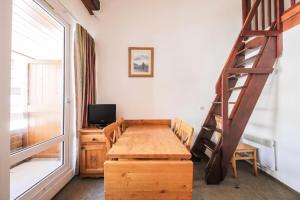 une pièce avec une table en bois et une échelle dans l'établissement Résidence Les Horizons d'Huez - maeva Home - Appartement 2 Pièces 6 Personnes - Confort MAE-8120, à Huez