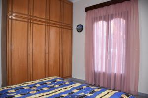 a bedroom with a bed and a dresser and a window at Val's place in Mytilene