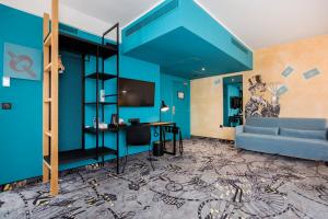 een blauwe kamer met een bank en een bureau bij ibis Styles Szczecin Stare Miasto in Szczecin