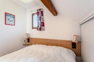 - une chambre avec un lit blanc et une fenêtre dans l'établissement Résidence les Chalets D'aurouze - maeva Home - Appartement 2 Pièces 4 Perso 01, à Saint-Étienne-en-Dévoluy