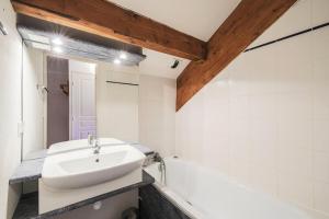 La salle de bains est pourvue d'un lavabo et d'une baignoire. dans l'établissement Résidence les Chalets D'aurouze - maeva Home - Appartement 2 Pièces 4 Perso 01, à Saint-Étienne-en-Dévoluy