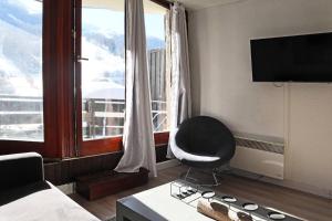 a living room with a chair and a large window at Résidence Les Carlines - Studio équipé pour 4 personnes vue pistes MAE-0214 in Les Orres