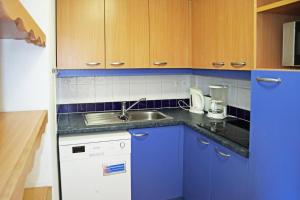 a kitchen with blue cabinets and a sink at Résidence Parc Des Airelles - 2 Pièces pour 6 Personnes 524 in Les Orres