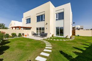 a house with a green lawn in front of it at URBANA III STACKED HOUSE -Dubai South in Dubai