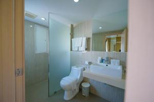 a bathroom with a sink and a toilet and a mirror at O2 Luxury Hotel in Bang Phli