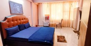 a bedroom with a large blue bed in a room at Family Homes in - Dwarka sec 8 Near Yashobhoomi in New Delhi