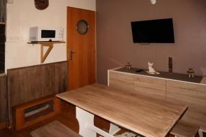 a living room with a table and a tv at Résidence Les Ecrins - Studio pour 2 Personnes 804 in Les Orres