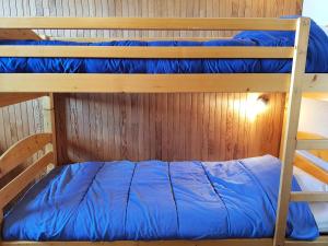 Łóżko piętrowe w pokoju z niebieską poduszką w obiekcie Résidence Cascade - Appartement 3 pièces 7 personnes à Arc 1600 ski aux pieds et proche des commerces MAE-2014 w mieście Arc 1600