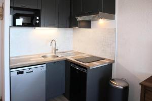 a small kitchen with a sink and a dishwasher at Résidence Les Carlines - Studio pour 4 Personnes 264 in Les Orres
