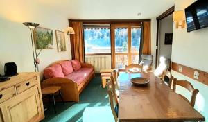 a living room with a table and a couch at LE MUSTAG - Appartement MUSTAG 26 pour 6 Personnes 55 in La Plagne