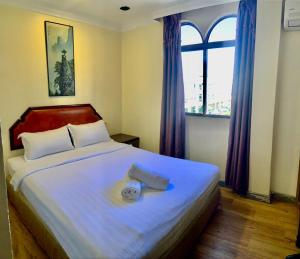 a bedroom with a large white bed with a window at Sogo Hotel 2 in Labuan