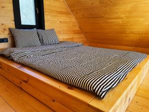 a bed sitting on a wooden platform in a cabin at Woodland Noszvaj in Noszvaj