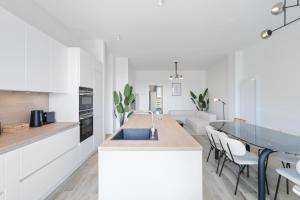 eine Küche mit weißen Schränken und ein Esszimmer in der Unterkunft Chic 3BR Penthouse with Balcony and Smart TV in Esch-sur-Alzette