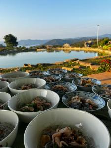 a bunch of bowls of food on a table at Phú Cường Tà Đùng Farmstay in Biđong