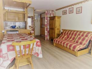 a bedroom with a bed and a table and a couch at Résidence Le Palafour - Studio pour 5 Personnes 52 in Tignes