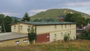 ein großes Gebäude mit einem Berg im Hintergrund in der Unterkunft Dom Gościnny Brama Sudecka in Lubawka