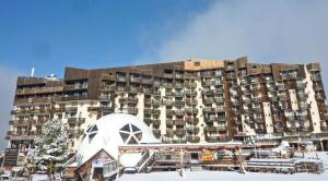 a large apartment building with a snow covered parking lot at Résidence Les Carlines - 2 Pièces pour 6 Personnes 284 in Le Mélézet