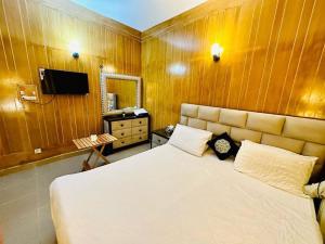 a bedroom with a large bed and a television at Islamabad guest house in Islamabad