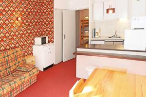 een woonkamer met een bank en een keuken bij Résidence Les Carlines - Studio pour 4 Personnes 204 in Le Mélézet