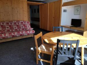 um quarto com uma mesa e cadeiras e uma cama em Résidence Cascade - Studio pour 5 Personnes 59 em Arc 1600
